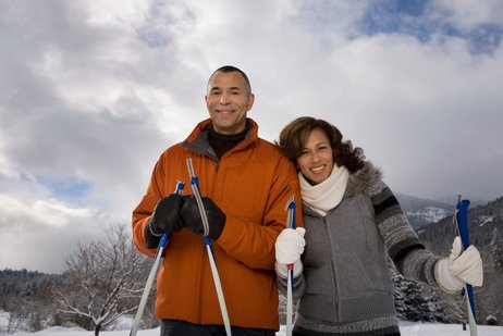 African American couple smiling with skis