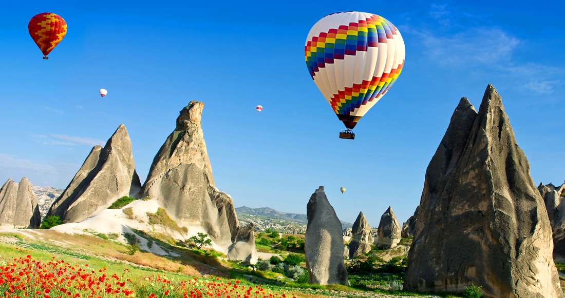 Hot air balloons flying over rock sculptures